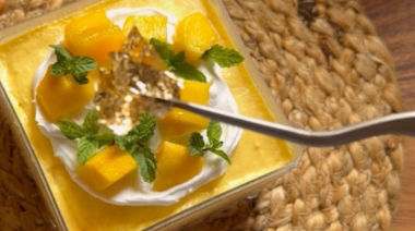 No-bake mango cheesecake jar topped with cream and fresh mango pieces